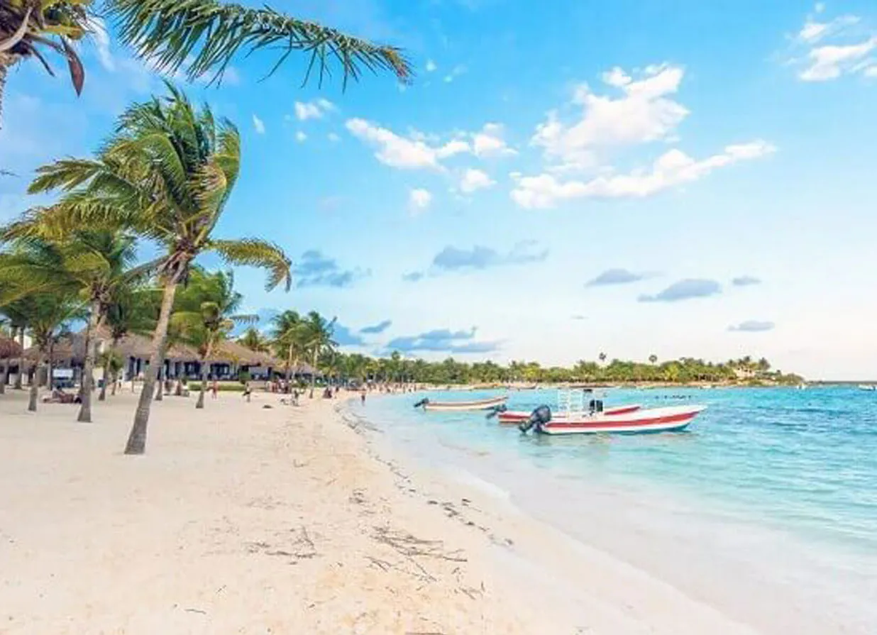 Palm trees, sand, sea and sky at a beach in Playa Paraiso. One of the destinations available for Cancun Airport Transportation